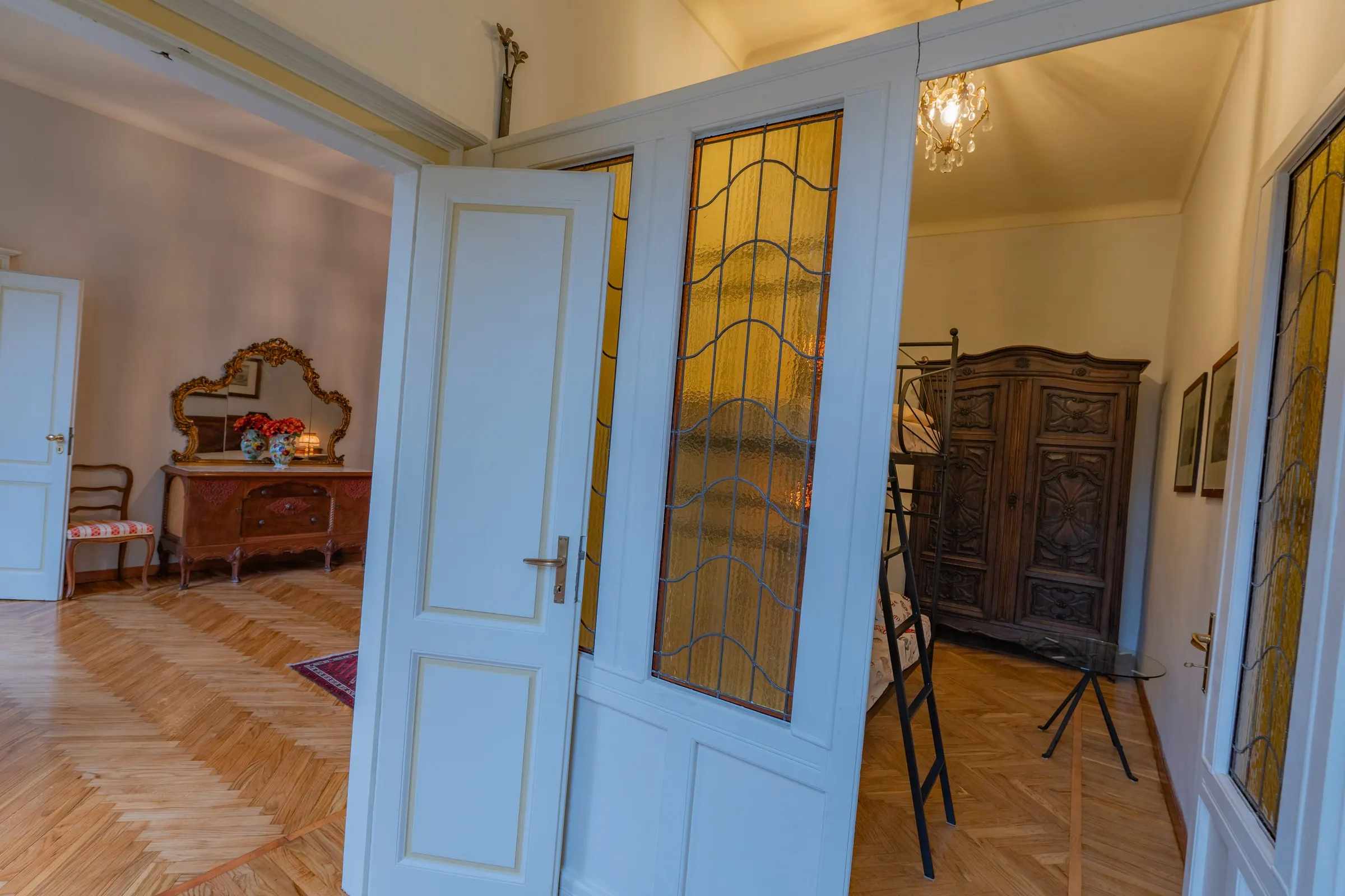 L’enfilade delle porte a vetri policromi, che inquadrano le stanze una dentro l’altra