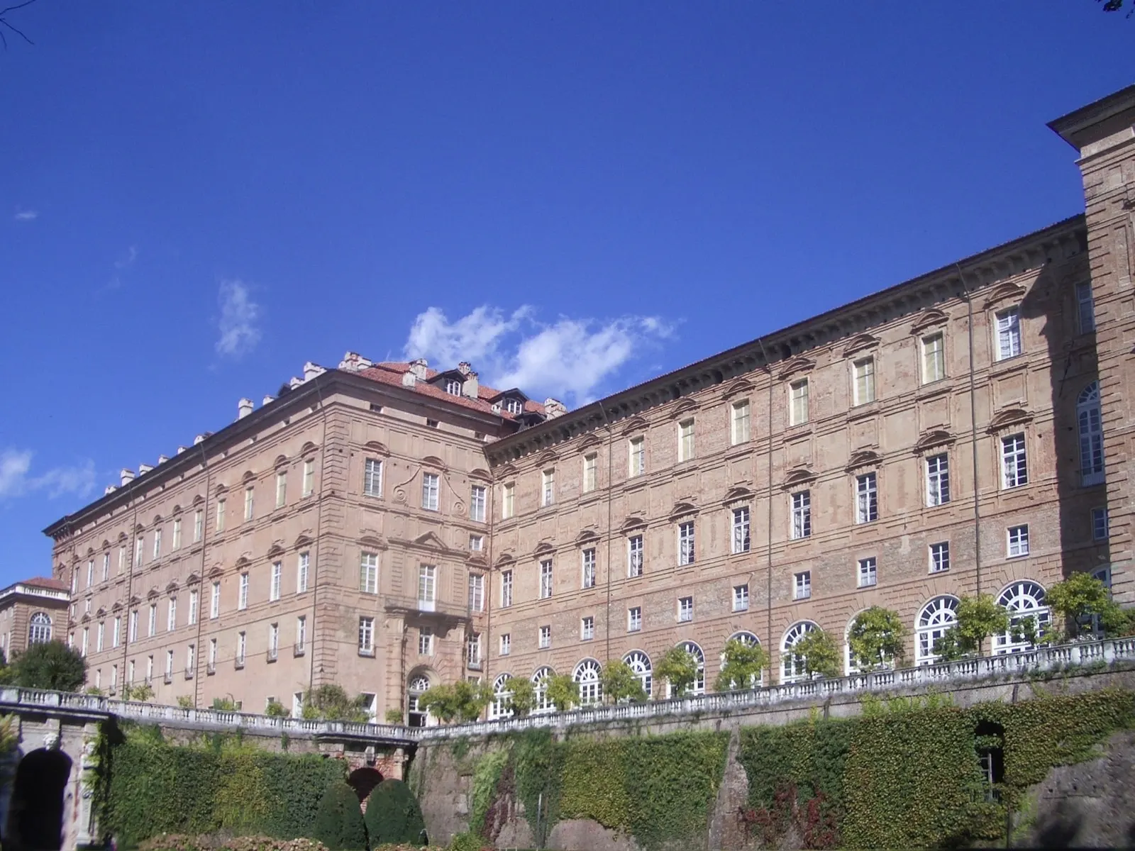 La lunga facciata del Castello di Agliè sul giardino, con le finestre a lunetta del piano terra e le siepi sotto la terrazza