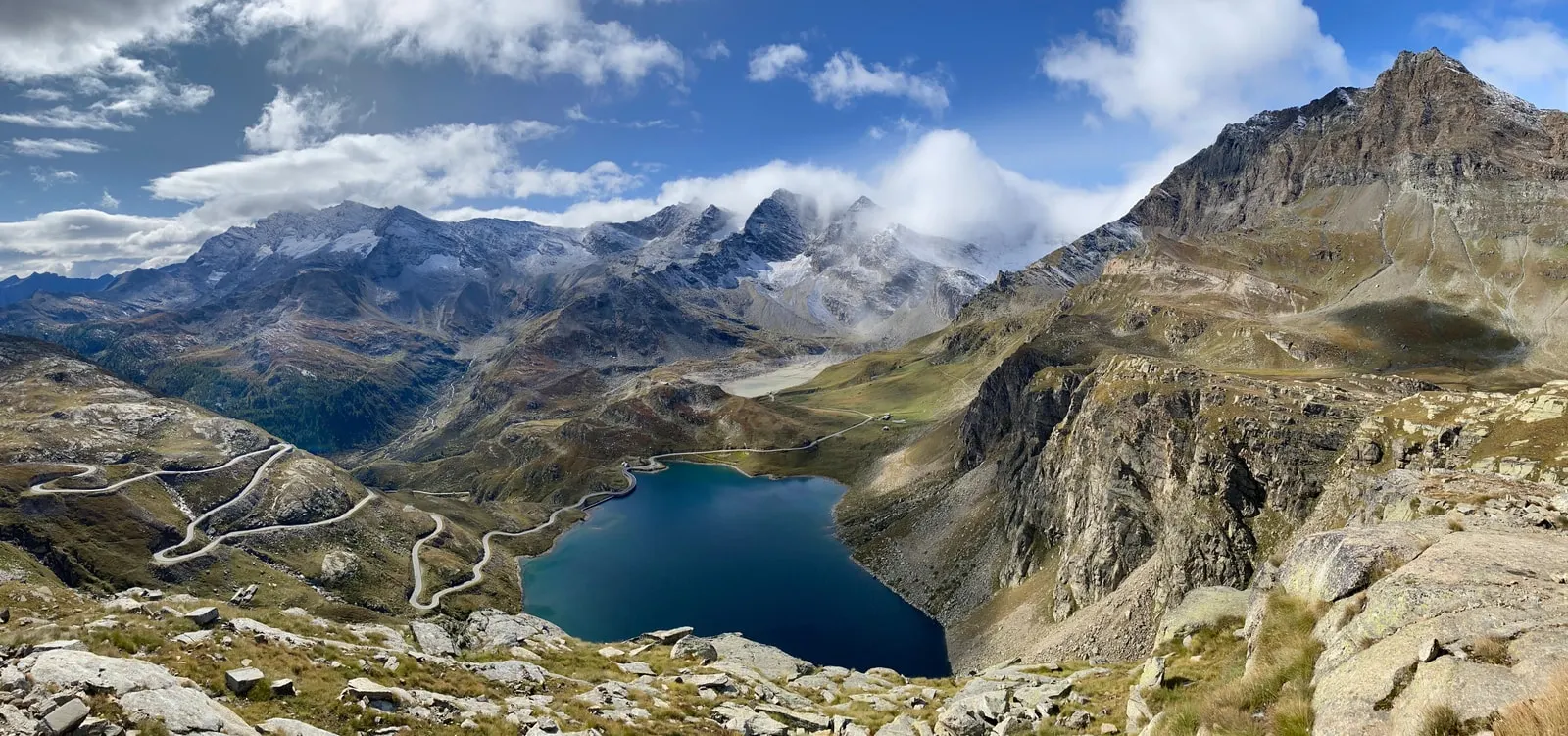 La strada del Nivolet che sale a tornanti e il Lago Serrù visti dal colle, fra le montagne del Gran Paradiso
