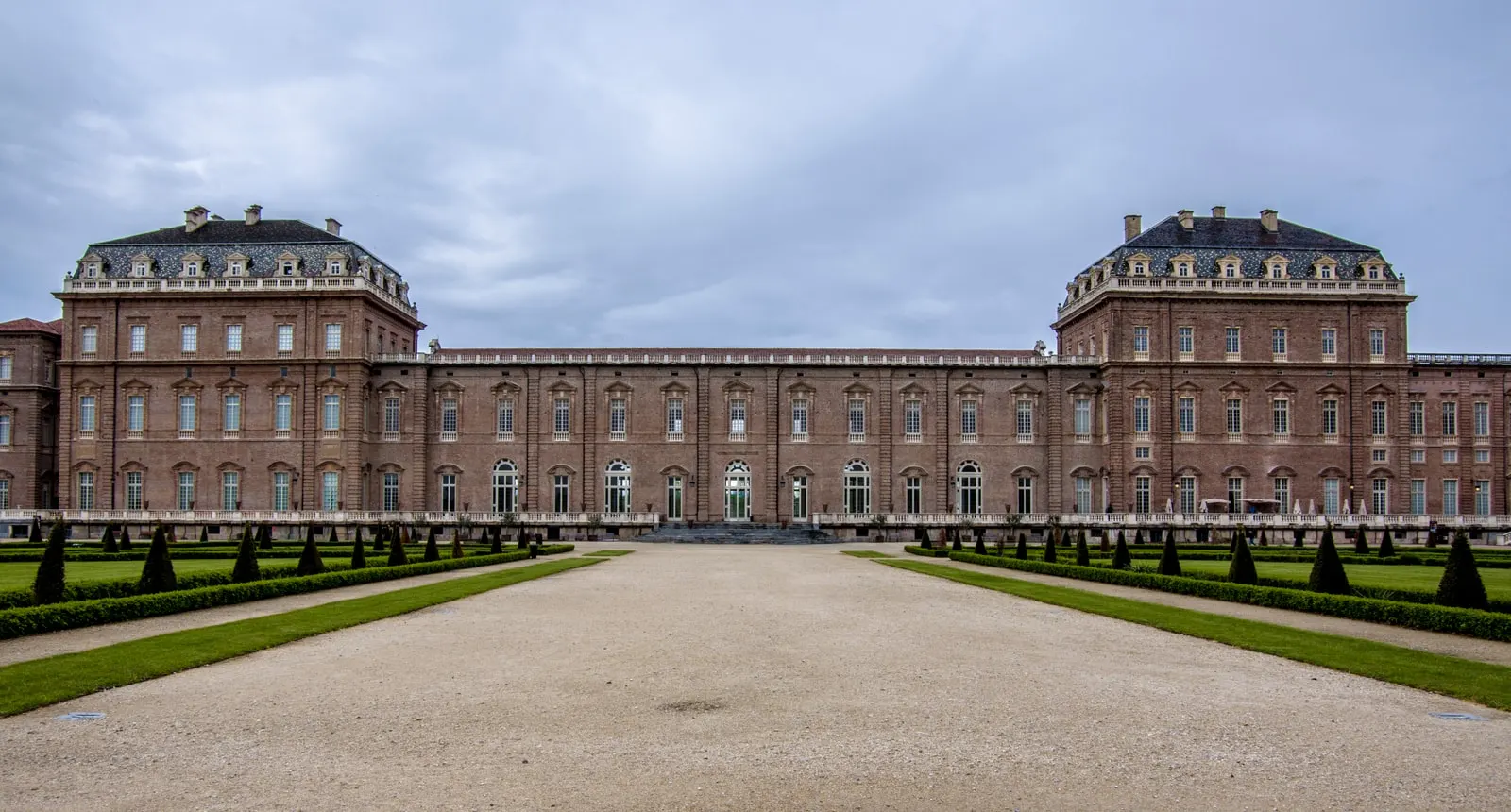 La facciata della Reggia di Venaria sui giardini, con il viale centrale e le siepi potate a cono